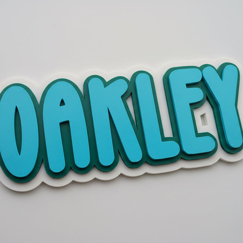 Blue 'OAKLEY' name sign on a white background